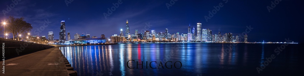 Obraz premium Chicago city downtown night panorama urban skyline with skyscrapers over Lake Michigan with clear blue sky.
