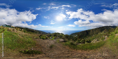 Spherical panorama: View of the Atlantic Ocean on Madeira island next to the starting point of a levada trail. Blue sky and cumulus humilis clouds over the valleys of Tabua and Ponta do Sol.