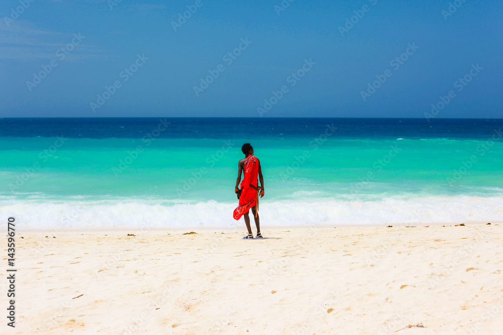 masai on a beach and blue sea Zanzibar, Tanzania - obrazy, fototapety, plakaty 