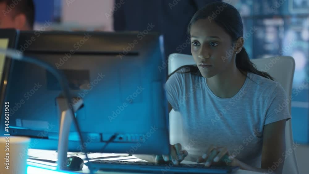  Young creative computer game designer working with colleagues in dark office. 