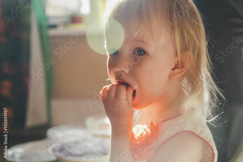 Little girl is eating a sandwich with caviar