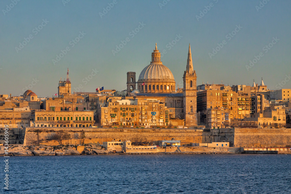 Malta - Valetta - Valetta's cityscape at dusk with harbor waterfront and Our Lady of Mount Carmel catholic church. Taken from Sliema