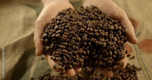 Hand dropping coffee beans slow motion. High quality 4k