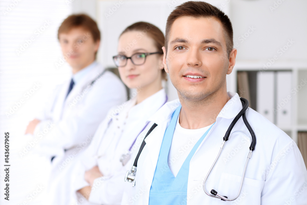 Cheerful smiling male doctor with medical staff at the hospital Cheerful smiling male doctor with medical staff at the hospital