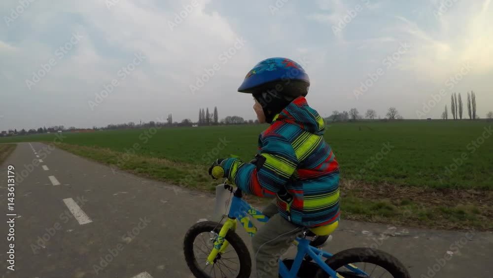 Cute little boy riding a bike.
Boy riding a bike along the cycle path.