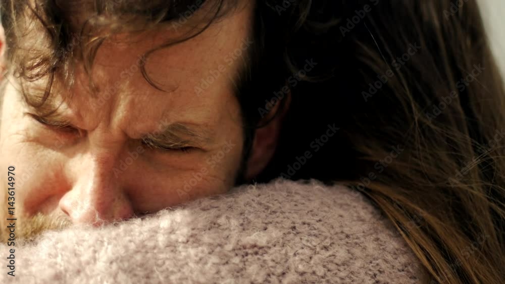 Sad man in love hugging girlfriend crying slow motion profile extreme closeup at sunset