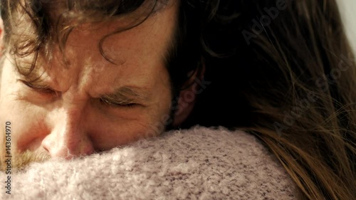 Sad man in love hugging girlfriend crying slow motion profile extreme closeup at sunset