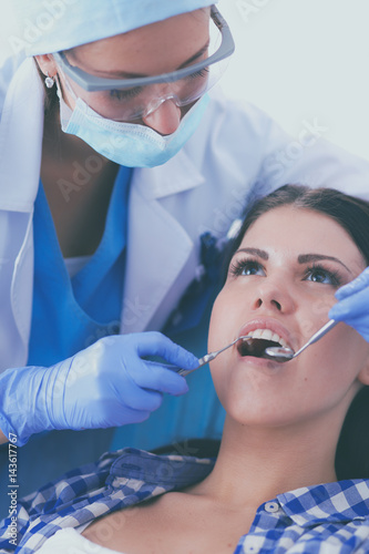 Woman dentist working at her patients teeth