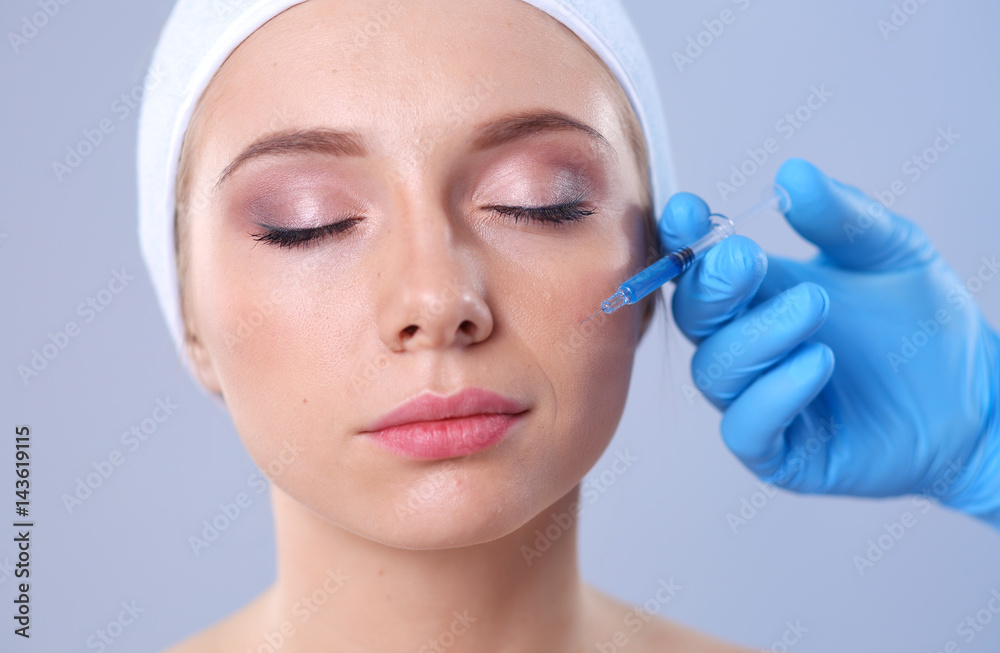 Cosmetic injection the pretty woman face. Isolated on gray background Cosmetic injection the pretty woman face. Isolated on gray background