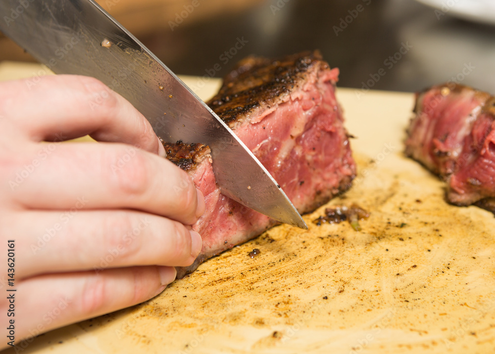 A knife slicing through a delicious grilledT Bone steak