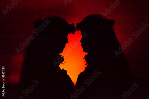Profile of Hawaiian women hula dancing in front of volcano