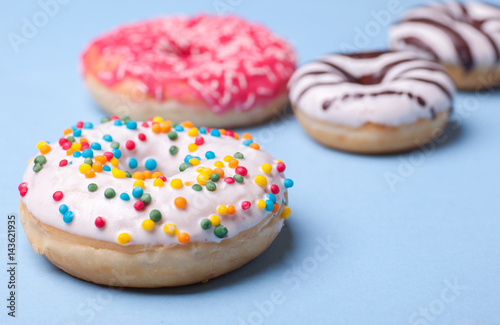 four tasty glazed donuts isolated on blue background
