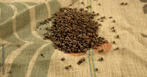 Coffee beans falling on a jute. Slow motion