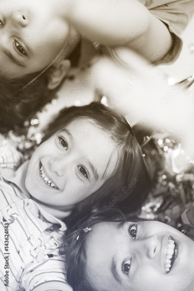 kids  blowing confetti while lying on the floor