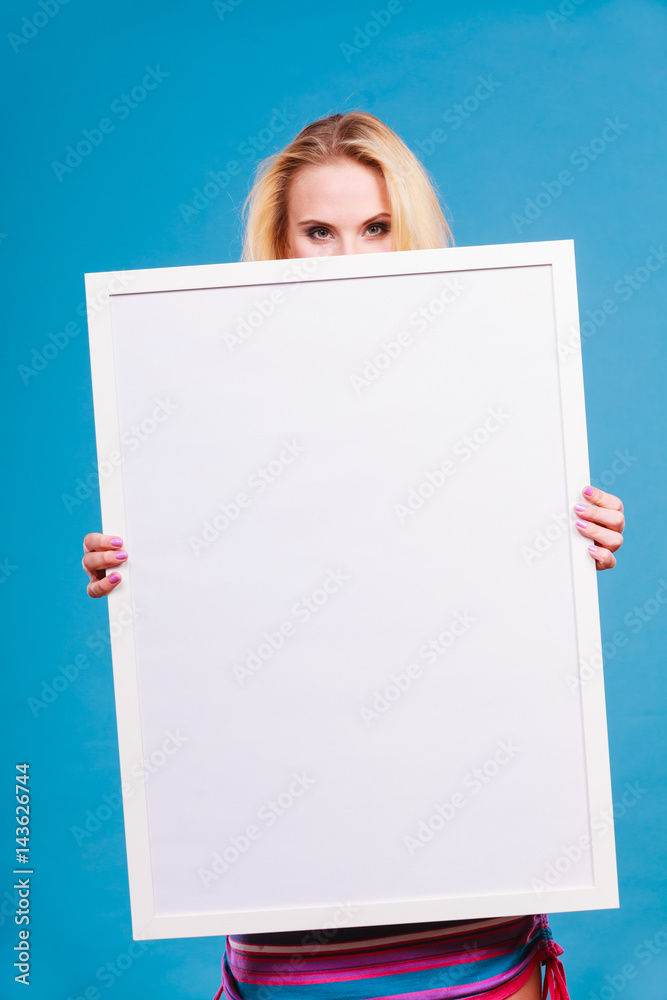 Happy positive blonde woman holding blank white board