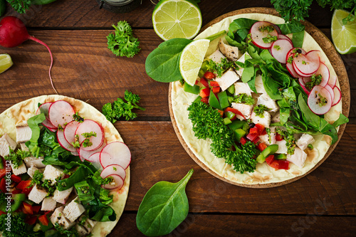 Healthy mexican corn tacos with boiled chicken breast, spinach, radish and paprika. Flat lay. Top view