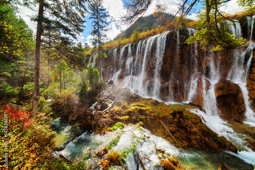 Fototapeta Naklejka Na Ścianę i Meble -  The Nuo Ri Lang Waterfall (Nuorilang) among autumn woods