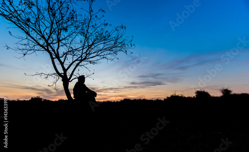 silhouettes Man sitting under the tree 