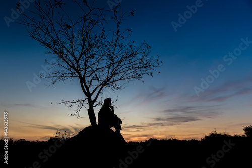 silhouettes Man sitting under the tree 