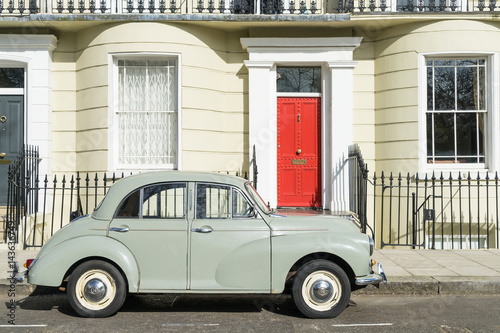 London - March 30: Oldtimer car parked in front of Kensington luxury town house on March 30, 2017. © iconimage