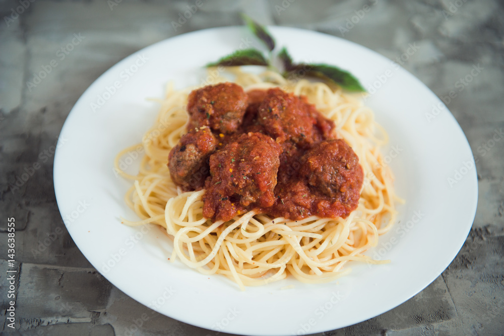 spaghetti and meatballs on a white plate. Close up