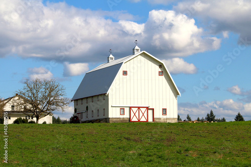 Large White Barn with Red Trim, Vivid Green Grass/Blue Sky, Bright White Clouds, Daytime - Center frame, front quarter viewpoint (HDR Image)