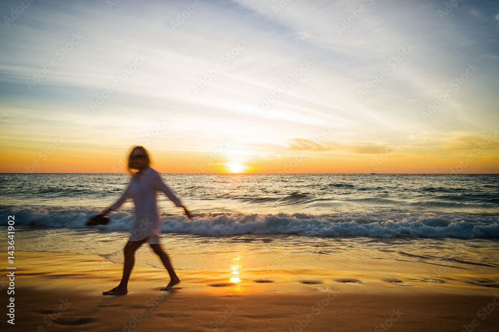 Silhouette young woman on the beach at sunset