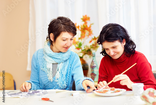 adult woman with special needs are engaged in handcraft in rehabilitation center photo