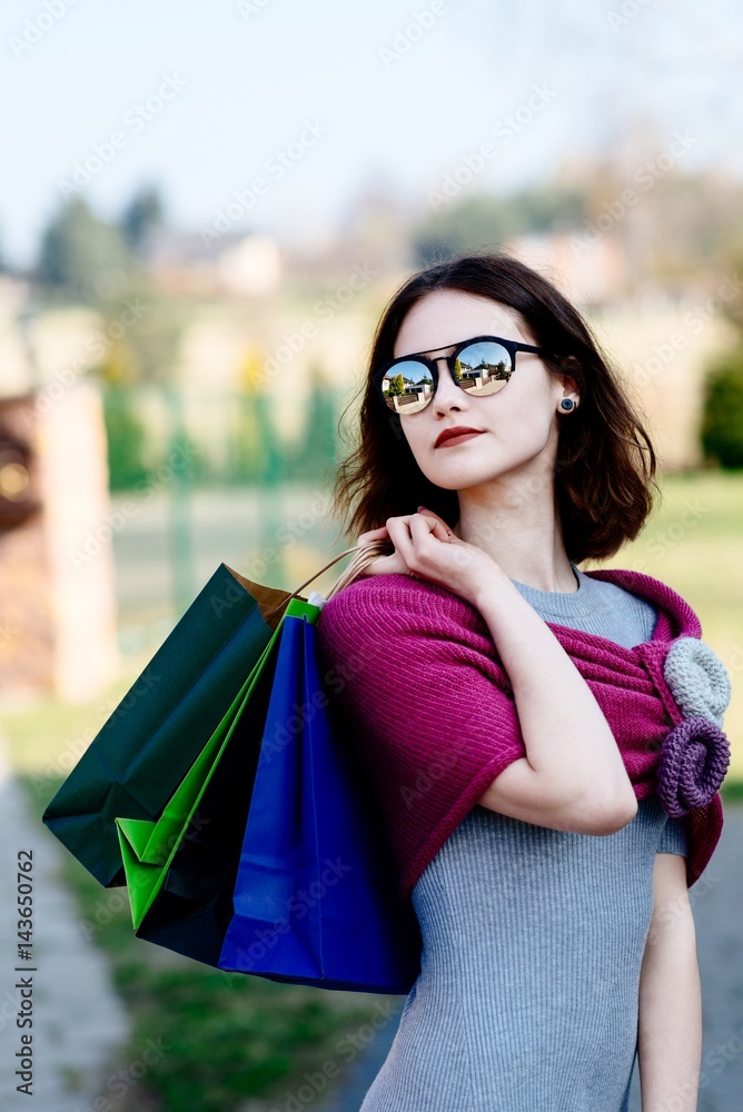Fashion girl in pink woolen shawl holding paper shopping bags. Fashion girl in pink woolen shawl holding paper shopping bags.