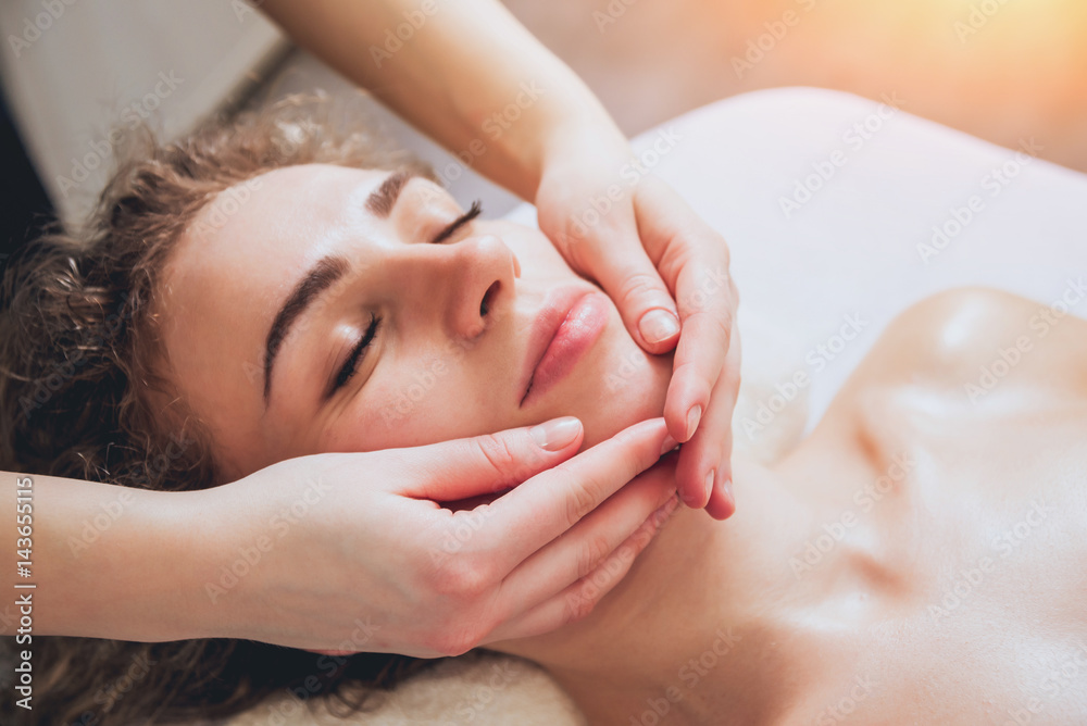 Beautiful woman in spa salon getting facial massage