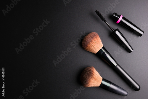 Fototapeta Naklejka Na Ścianę i Meble -  Set of flat top view of various professional female cosmetics brushes for makeup and eyelash brush isolated on black background, Cosmetics concept, Makeup concept, Copy space image for your text.