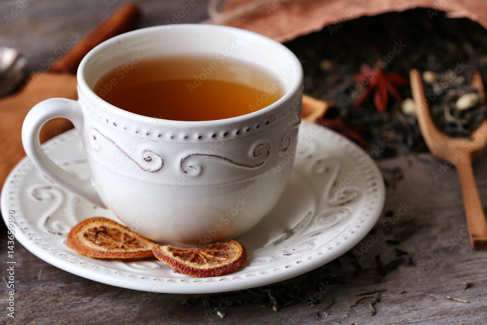 Cup of tea with dried leaves on wooden table Cup of tea with dried leaves on wooden table