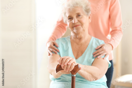 Young girl hugging old woman on blurred background