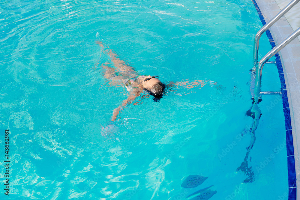 woman swimming on a blue water pool