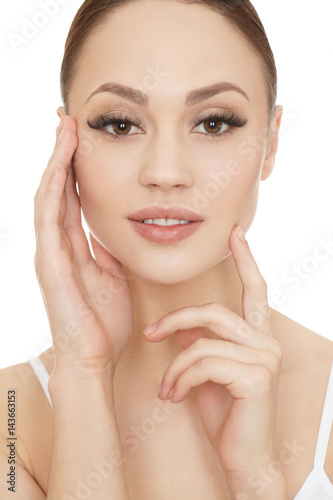 Picture of health. Young pretty woman posing touching her face isolated on white.