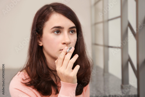 Portrait of smoking teenage girl on stairs