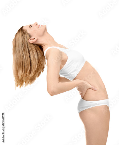 Young woman suffering from back pain on white background