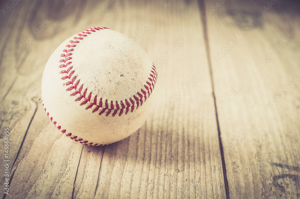 Old baseball ball on wooden background and highly closeup Old baseball ball on wooden background and highly closeup