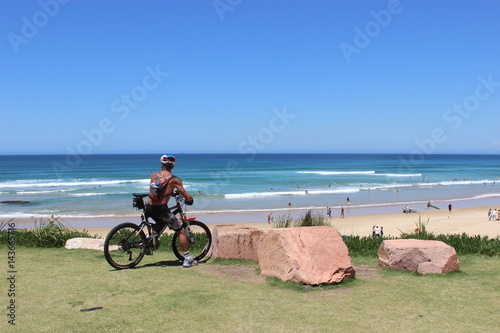 Biker is looking on the beach