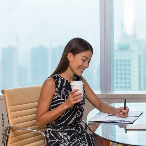Businesswoman working at office drinking coffee