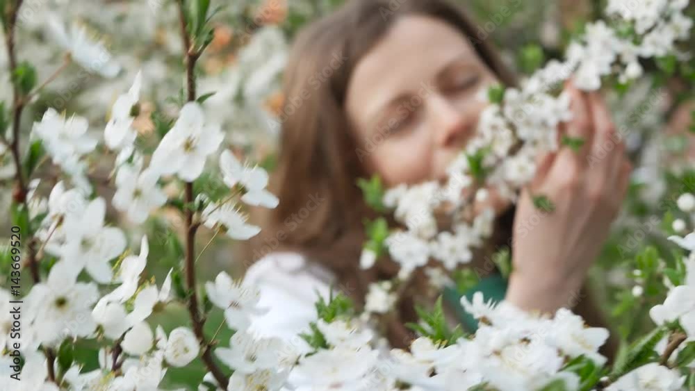 outdoor portrait of a beautiful woman in white jacket among white blossom tree outdoor portrait of a beautiful woman in white jacket among white blossom tree