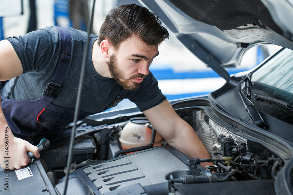 Mechanic repairing a car at the garage Mechanic repairing a car at the garage