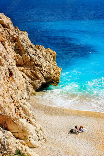 Tourist sunbathing on a deserted beach in the Mediterranean Sea photo