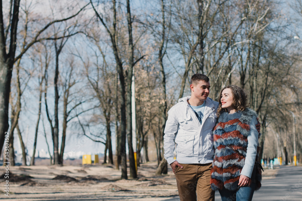 Happy couple in love hugging and sharing emotions, holding hands walking in the park