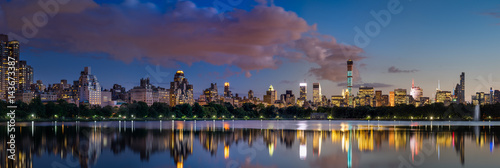 Panoramic view of the Central Park Reservoir and Midtown skyscrapers illuminated at twilight in Summer. Manhattan, New York City