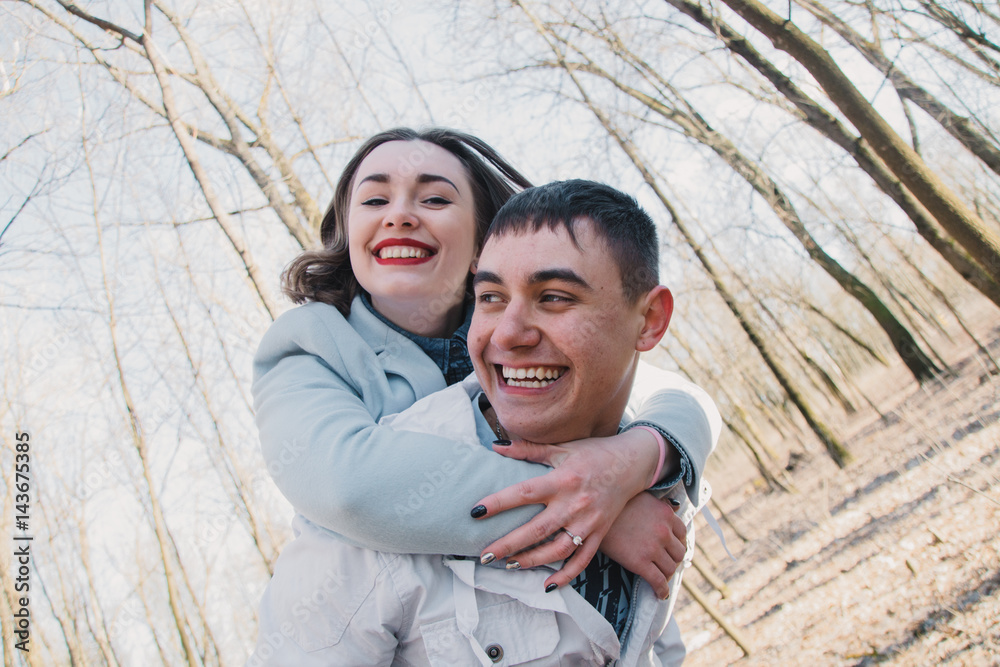 Happy couple in love hugging and sharing emotions, holding hands walking in the park Happy couple in love hugging and sharing emotions, holding hands walking in the park