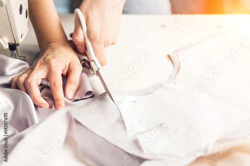dressmaker working with scissor in the sewing workshop