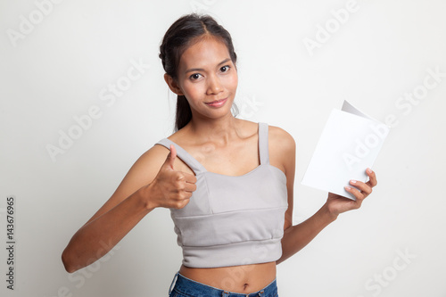 Young Asian woman thumbs up with a book.
