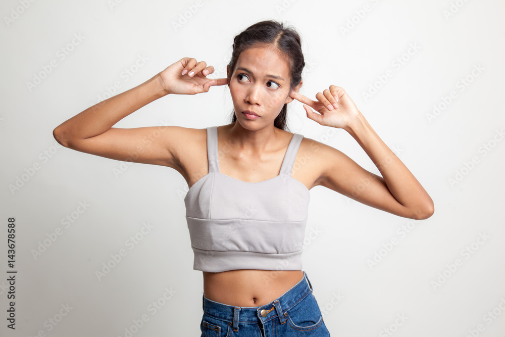 Young Asian woman block both ears with fingers.