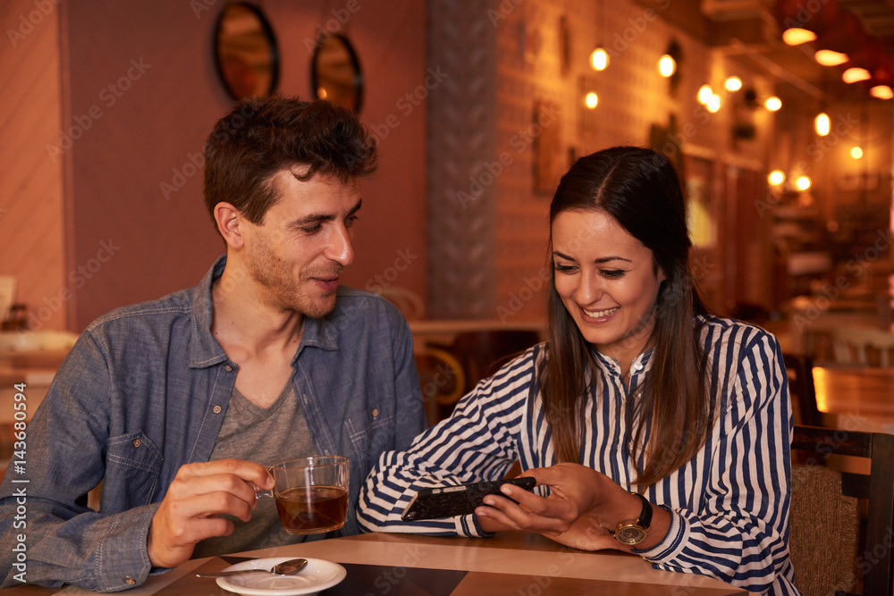 Loving millenial couple sitting in restaurant Loving millenial couple sitting in restaurant